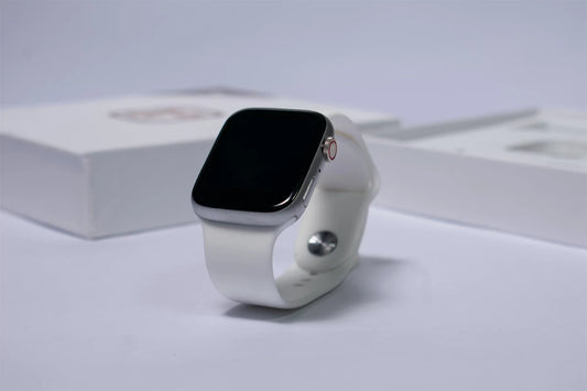 white sport band apple watch series 8 45mm on a white table with some boxes